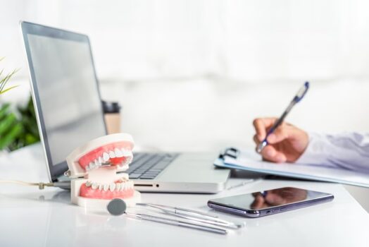 dentist doctor in uniform writing information of patient in paperwork